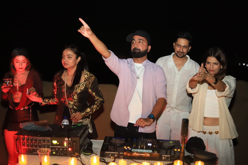 The batch dancing around the DJ booth under candlelight